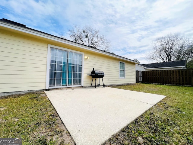 view of patio with fence and a grill