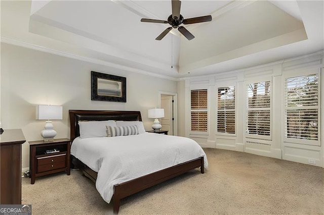 bedroom featuring crown molding, a raised ceiling, a ceiling fan, and light colored carpet