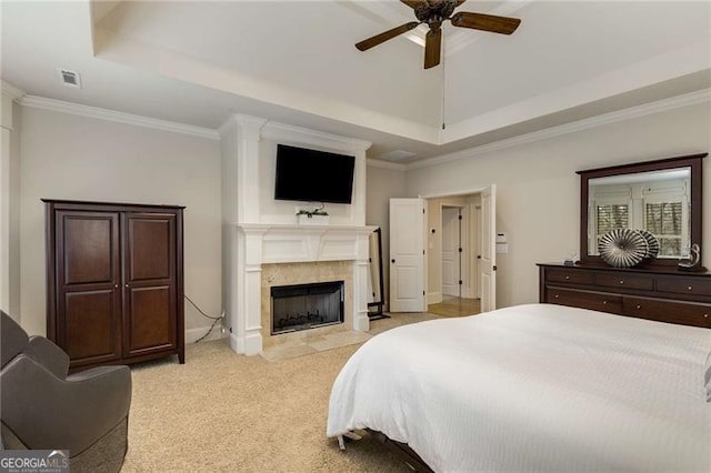 bedroom with a fireplace with flush hearth, a raised ceiling, visible vents, and light carpet