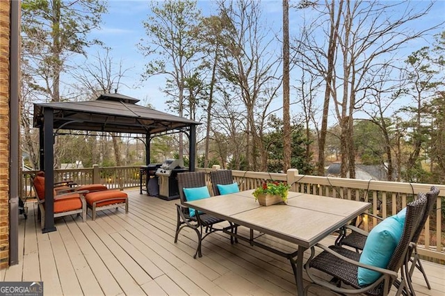 wooden terrace featuring outdoor dining area and a gazebo