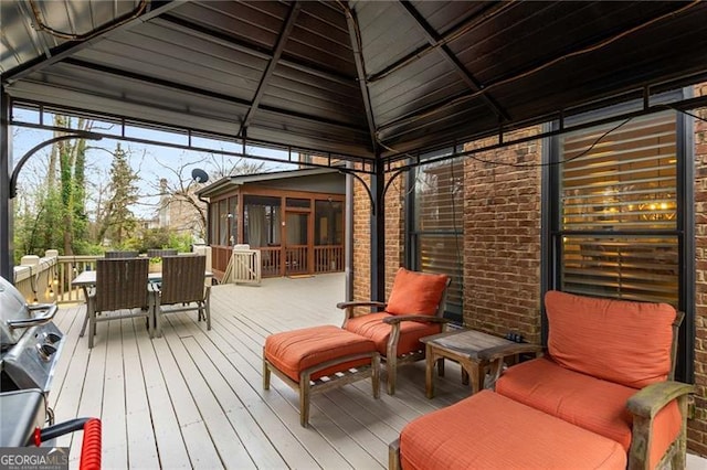 deck featuring outdoor dining space and a sunroom