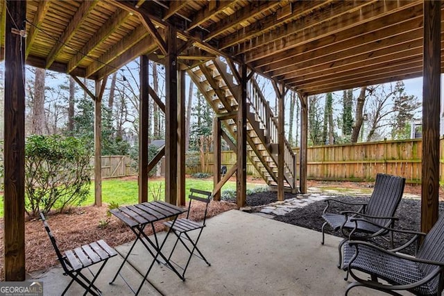 view of patio / terrace with fence and stairway