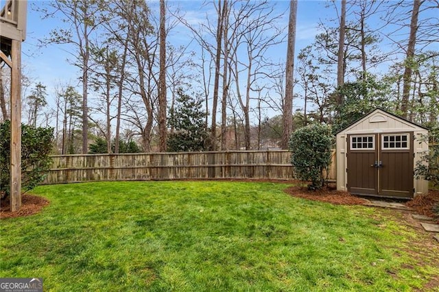 view of yard with an outbuilding, a fenced backyard, and a storage shed