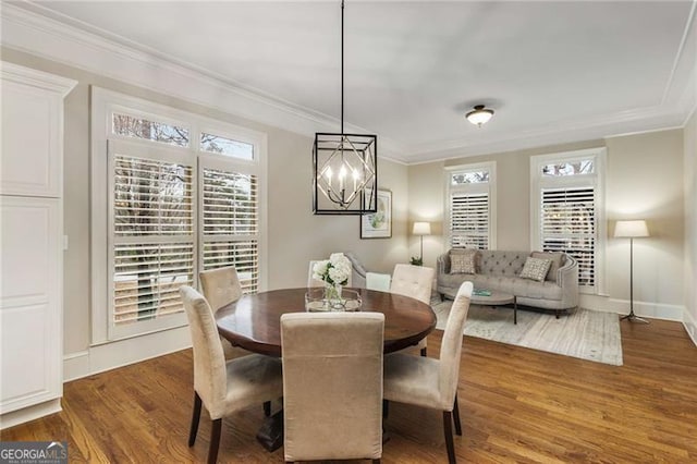 dining space with a notable chandelier, baseboards, crown molding, and wood finished floors