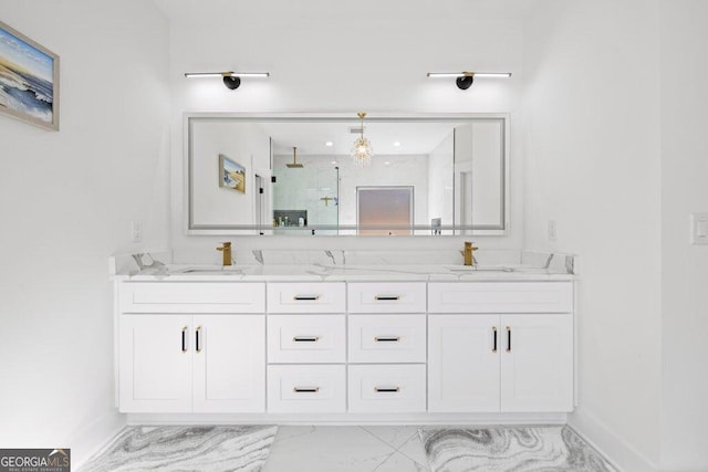 bathroom featuring marble finish floor, double vanity, walk in shower, and a sink