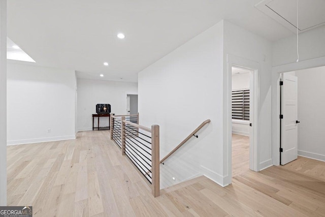 hall featuring light wood-style flooring, recessed lighting, an upstairs landing, baseboards, and attic access