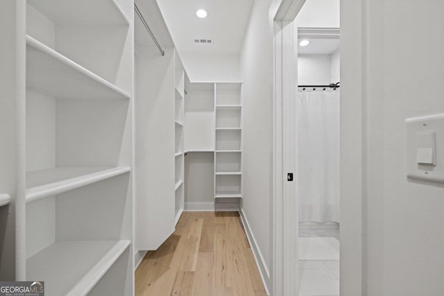 walk in closet featuring wood finished floors and visible vents