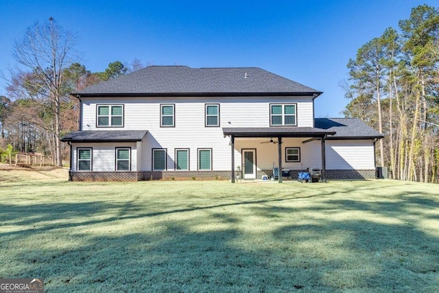 back of property featuring a ceiling fan, a lawn, and brick siding