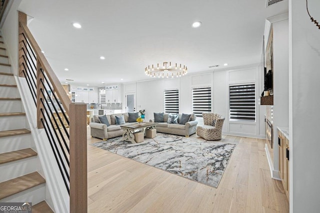 living room with light wood-type flooring, stairs, visible vents, and recessed lighting