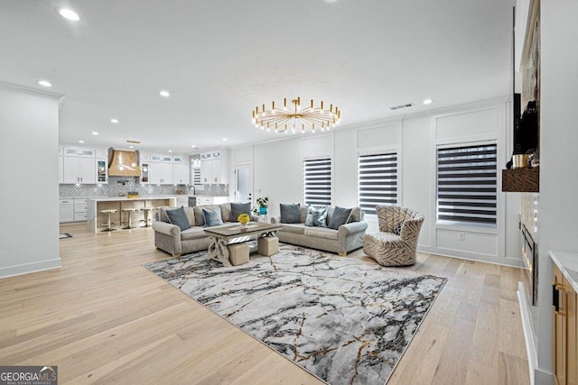 living room featuring light wood-style flooring, visible vents, and recessed lighting