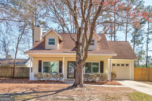 cape cod-style house featuring a garage, driveway, fence, and a porch