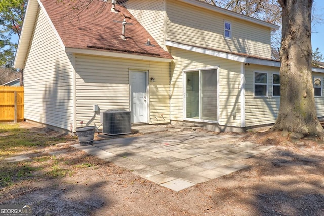 back of house featuring a shingled roof, a patio, fence, and central air condition unit