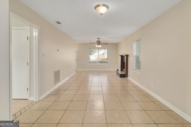2 Hickory Rd, Rincon, GA 31326 - unfurnished living room featuring a ceiling fan, light tile patterned floors, a fireplace with raised hearth, and baseboards