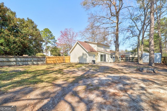 exterior space with an outbuilding, a shed, and a fenced backyard