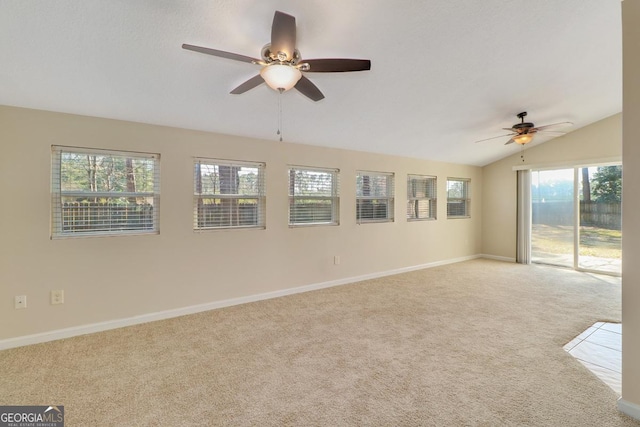 carpeted empty room featuring ceiling fan, baseboards, and vaulted ceiling