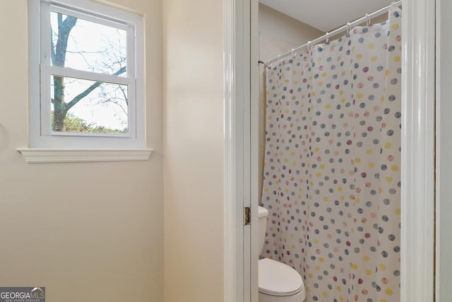 full bathroom with a shower with shower curtain and toilet