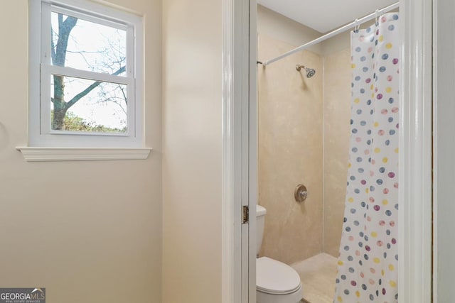 bathroom with a shower stall and toilet