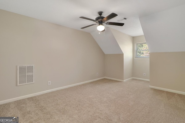 additional living space with light carpet, lofted ceiling, visible vents, and baseboards