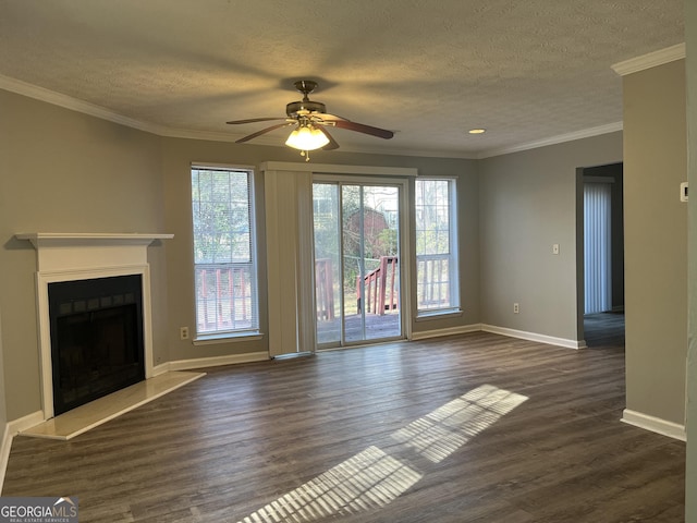 unfurnished living room with baseboards, a fireplace with raised hearth, ornamental molding, dark wood-style flooring, and a textured ceiling