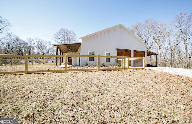 back of property with ceiling fan, fence, and an outdoor structure