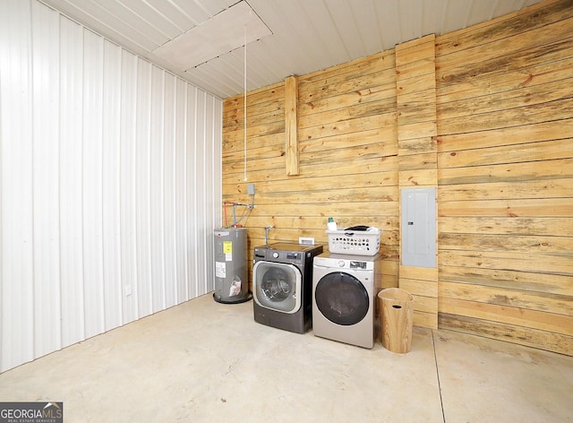 laundry room with electric water heater, wooden walls, laundry area, separate washer and dryer, and electric panel