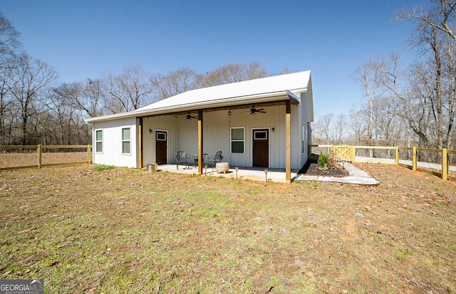 rear view of property featuring a ceiling fan, a fenced backyard, and a patio