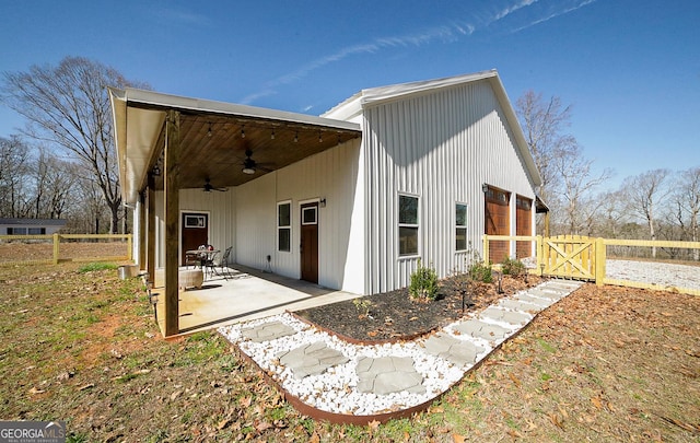 view of side of home featuring a gate, ceiling fan, a patio, and fence