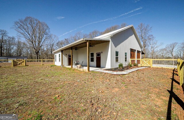 view of side of property with a gate, a patio area, ceiling fan, and fence