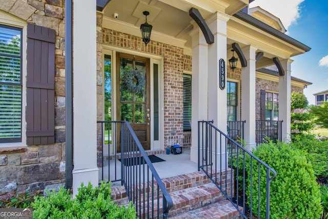 4590 Gablestone Xing, Hoschton, GA 30548 - entrance to property featuring brick siding, covered porch, stone siding, and a surveillance system
