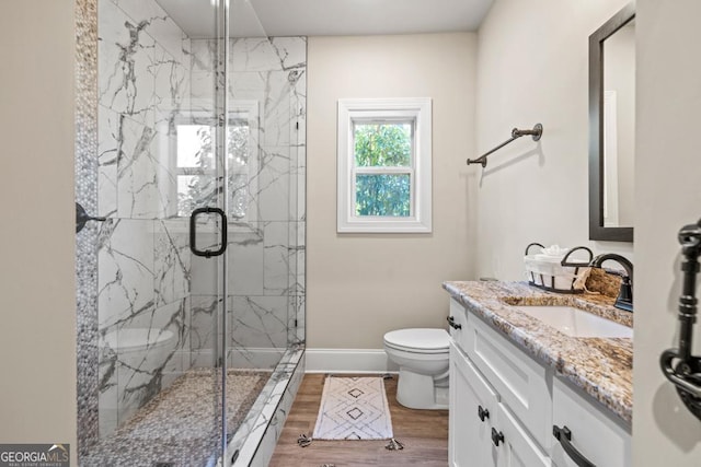 4590 Gablestone Xing, Hoschton, GA 30548 - full bathroom featuring toilet, a marble finish shower, vanity, wood finished floors, and baseboards