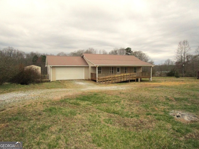 single story home featuring a garage, a front lawn, metal roof, and dirt driveway