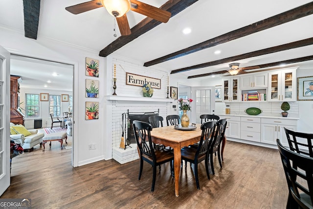 dining area featuring a brick fireplace, ceiling fan, dark wood finished floors, beamed ceiling, and recessed lighting