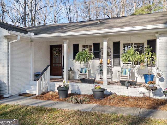 property entrance featuring brick siding and a porch