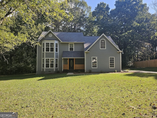 traditional-style house with crawl space, a front yard, and fence