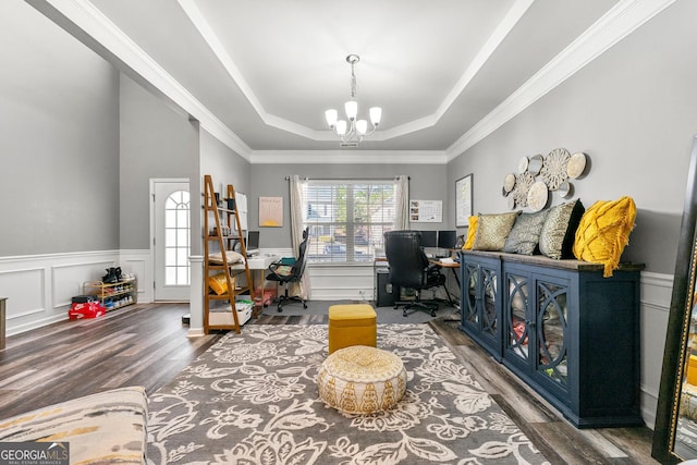 interior space featuring a wainscoted wall, a notable chandelier, a raised ceiling, a decorative wall, and wood finished floors