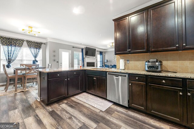 kitchen featuring ornamental molding, a peninsula, stainless steel dishwasher, and decorative backsplash