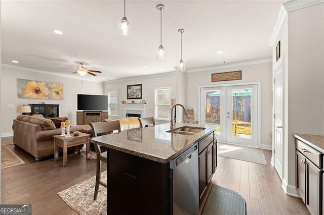 kitchen with a fireplace, a sink, french doors, stainless steel dishwasher, and crown molding