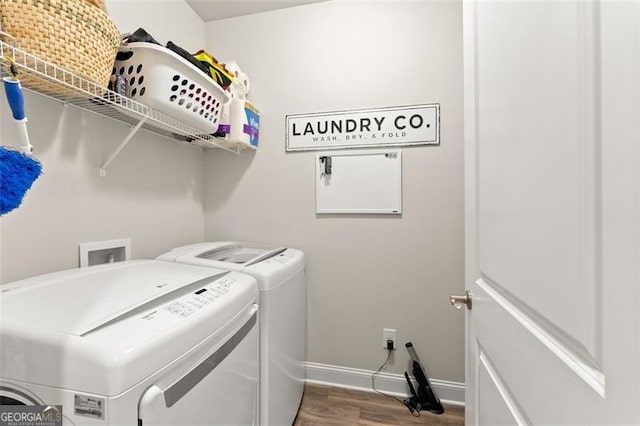 washroom with washer and dryer, laundry area, baseboards, and wood finished floors