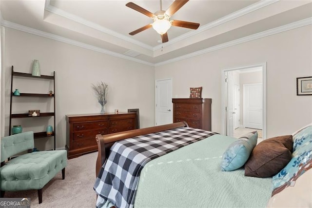 bedroom featuring a tray ceiling, light carpet, and crown molding