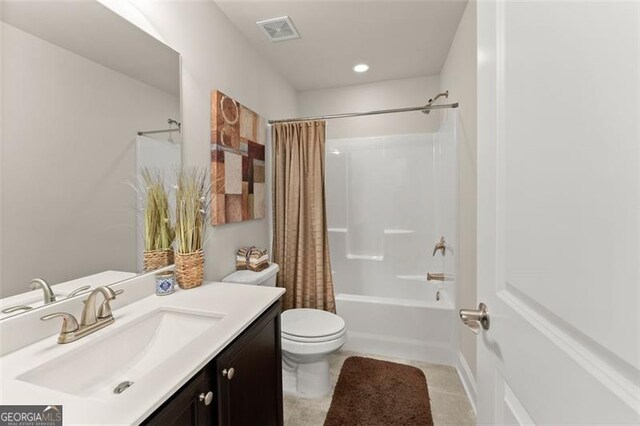 bathroom featuring shower / bath combination with curtain, visible vents, toilet, vanity, and tile patterned floors