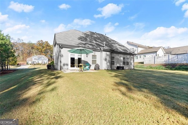 rear view of house featuring a lawn, cooling unit, and fence