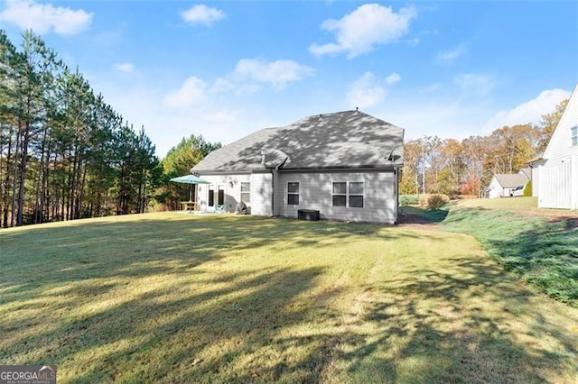 rear view of property featuring a yard