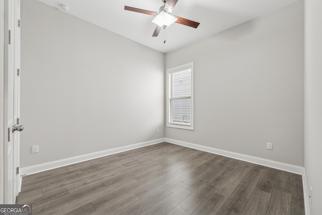 spare room with ceiling fan, wood finished floors, and baseboards