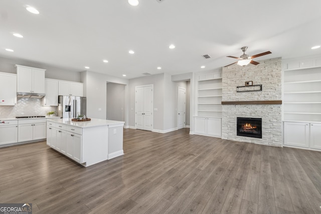 kitchen featuring a kitchen island, stainless steel fridge, stovetop, and wood finished floors