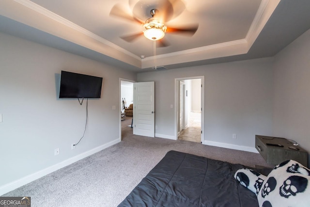 carpeted bedroom with baseboards, visible vents, ceiling fan, ornamental molding, and a tray ceiling