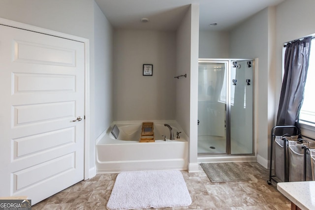 bathroom featuring a garden tub and a shower stall