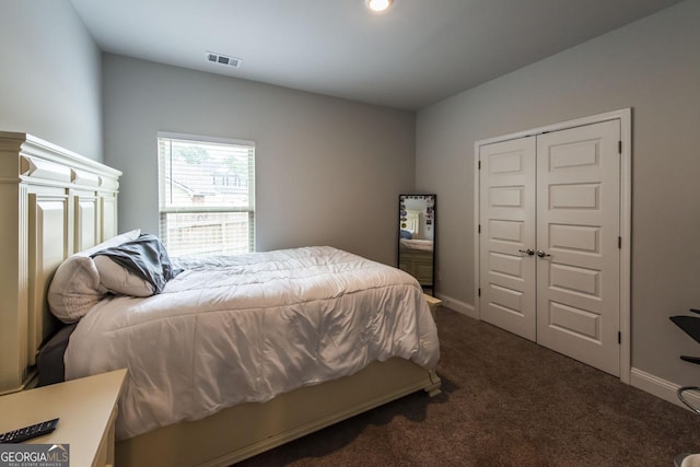 carpeted bedroom with a closet, visible vents, and baseboards