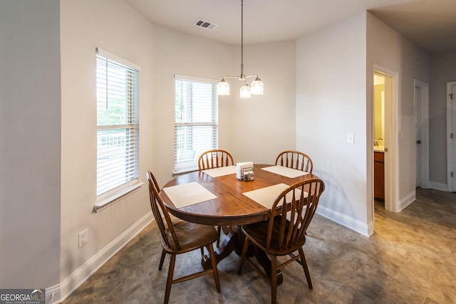 dining space with visible vents, a notable chandelier, and baseboards