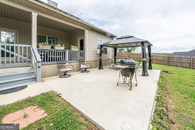 view of patio featuring covered porch, a gazebo, and fence