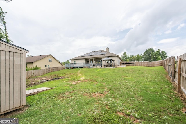 view of yard featuring a gazebo, a fenced backyard, and a wooden deck